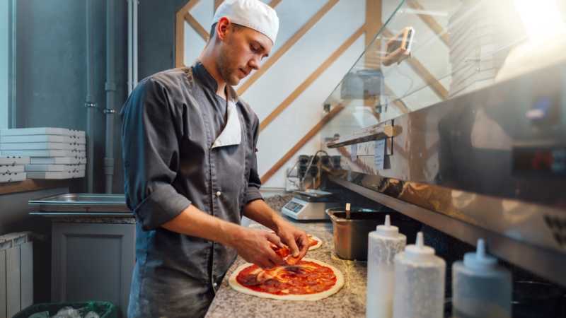 The chef prepares pizza. Catering kitchen work.